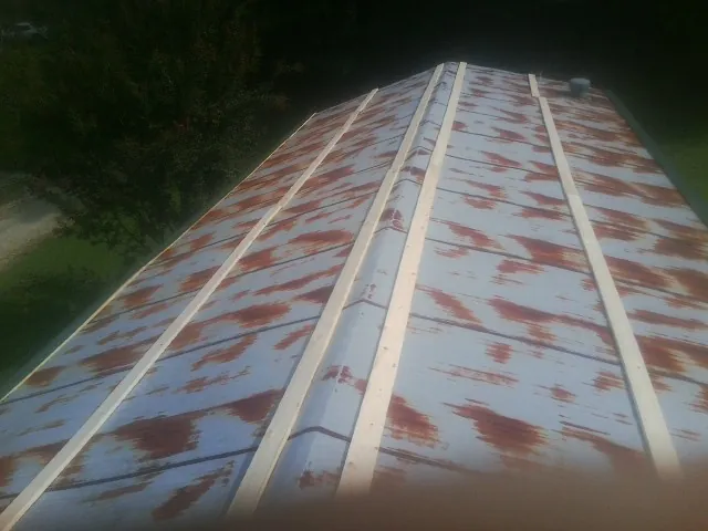 Rusted metal roof panels with new wood purlins before replacement — Storm Damage Roof Repair in Jonesboro by Roofing Brothers
